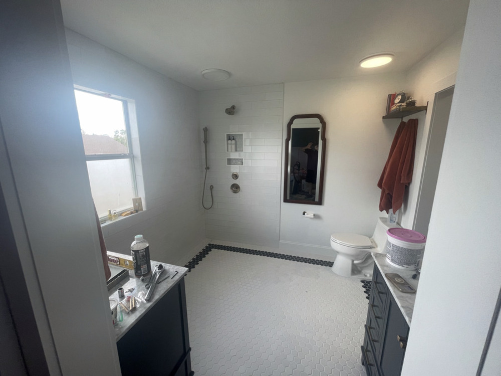 Finished primary bathroom with tiled shower and vanity